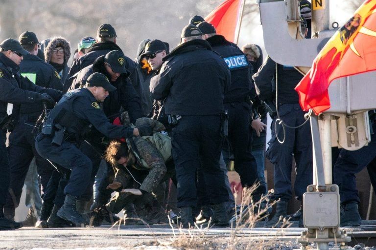 Police officers make an arrest during a raid on a Tyendinaga Mohawk Territory camp next to a railway crossing in Tyendinaga, Ontario, Canada February 24, 2020. (Carlos Osorio/Reuters)