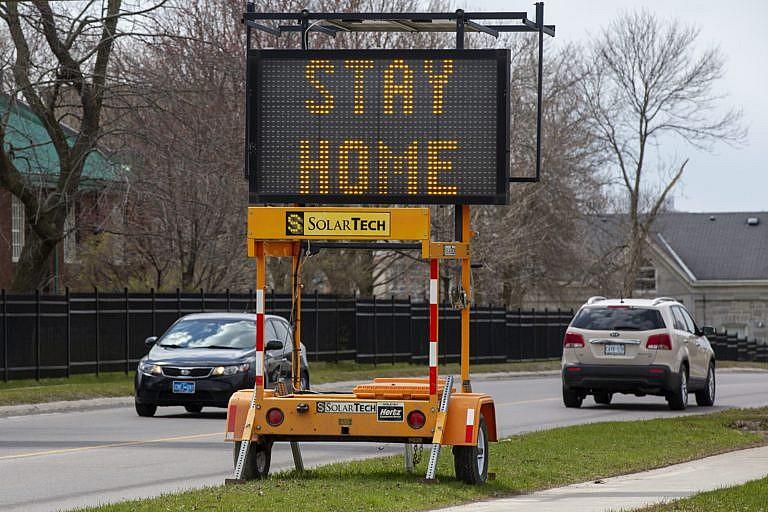 A sign tells people to stay home because of the COVID pandemic, along a road in Kingston, Ont., on April 17, 2020 (CP/Lars Hagberg)