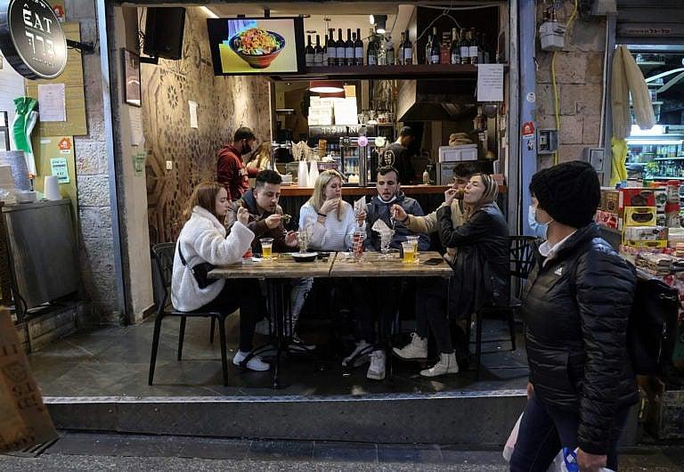 People eat at a restaurant in Jerusalem's main market after authorities reopened restaurants, bars and cafes to "green pass" holders (proof of having received a covid-19 vaccine), on March 11, 2021. (Emmanuel Dunand/AFP/Getty Images)