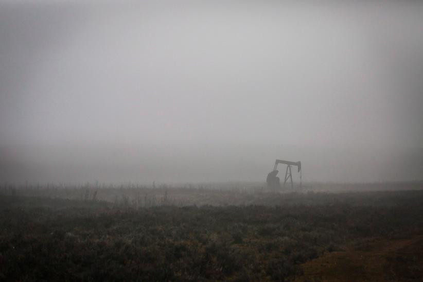 A pumpjack works at a well head on an oil and gas installation on a foggy day near Cremona, Alta., Saturday, Oct. 29, 2016. Oil and gas companies in Alberta are accelerating voluntary reclamation of old well sites and pipelines. (Jeff McIntosh/CP)