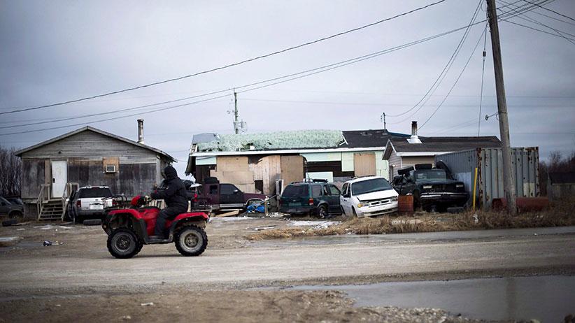 A man rides his ATV in the northern Ontario First Nations reserve in Attawapiskat, Ont., on Tuesday, April 19, 2016. In many ways, Attawapiskat - population 2,100 - has all the trappings of any small town, including older folk lamenting the changing of the times. (Nathan Denette/CP)