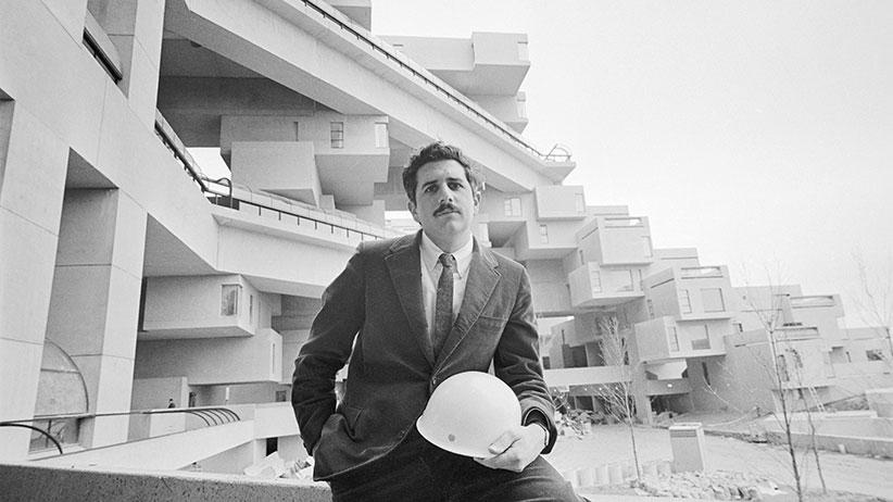 Architect Moshe Safdie, 28, sits on the railing of "Habitat," his answer to apartment housing that will be one of the more spectacular exhibits at the 1967 World Exhibition, (EXPO 67). There are 158 apartments here, laid out according to 15 separate floor plans. (Bettmann/Getty Images)