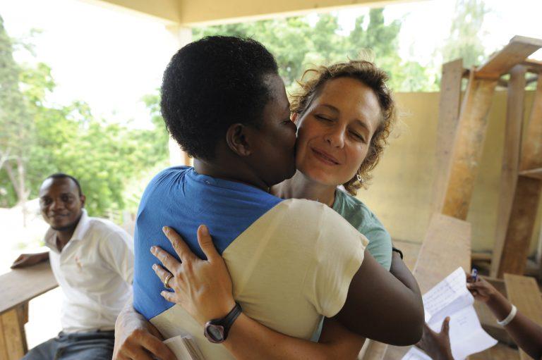 Catherine Porter is embraced by Roselene Derival Fabre(manager of the MOJUBPV) after Porter donated