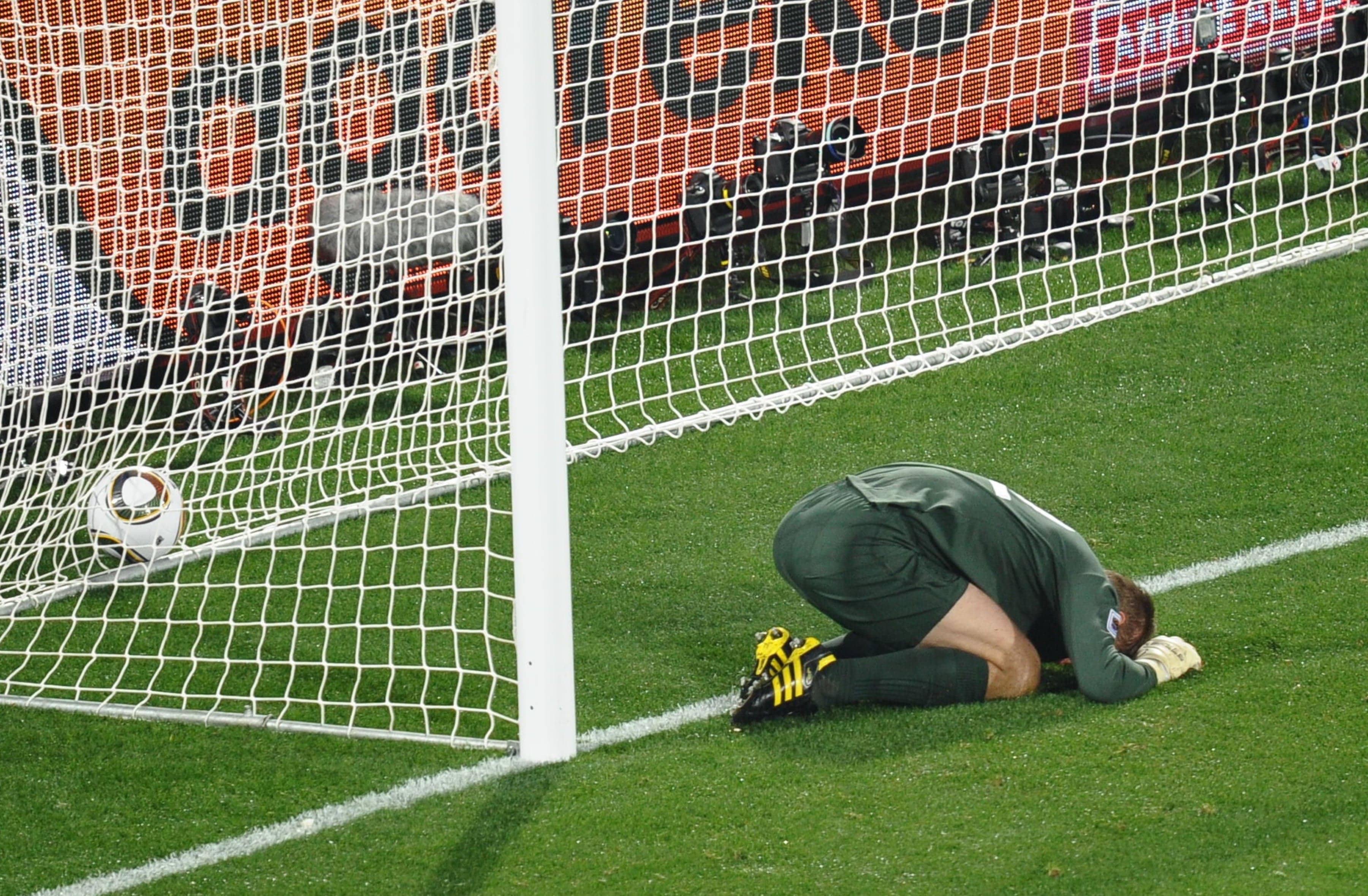 England's goalkeeper Robert Green reacts after missing a goal