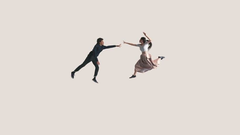 Young couple in air reaching out for each other