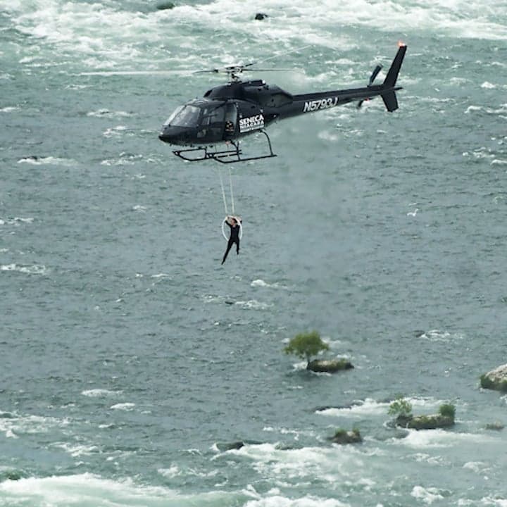 Aerialist casually hangs by her teeth over Niagara Falls