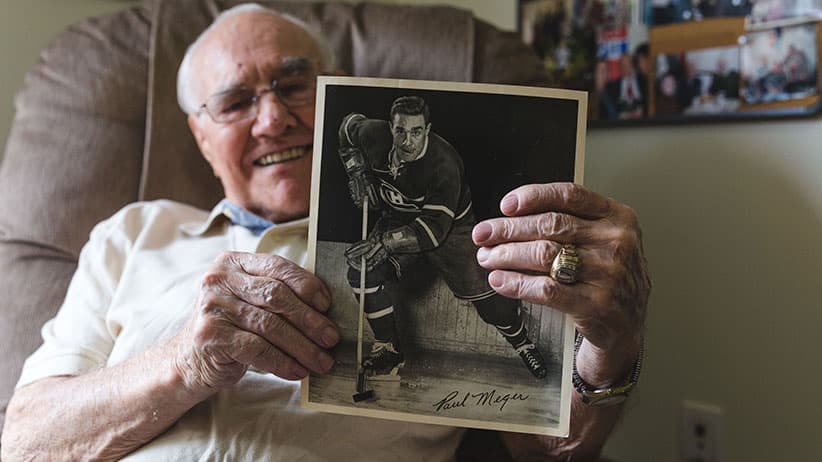 Paul Meger holds up photo of himself. (Photograph by Yasin Osman)