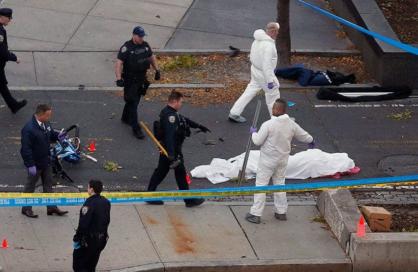 Authorities investigate the scene near a covered body on a bike path after a motorist drove onto the path near the World Trade Center memorial, striking and killing several people, Tuesday, Oct. 31, 2017, in New York. (Bebeto Matthews/AP/CP)