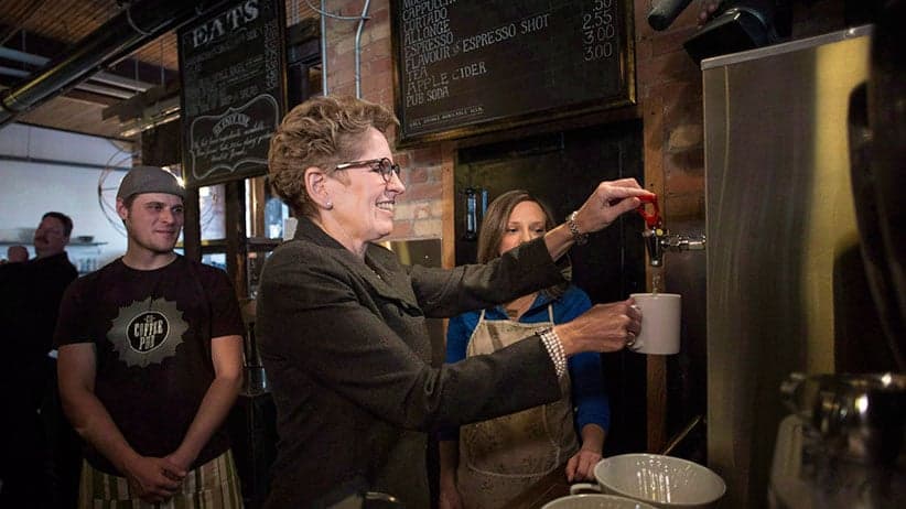 Ontario Premier Kathleen Wynne makes herself a cup of tea at a Toronto coffee shop, before making an announcement regarding the minimum wage in the province, on Thursday, January 30, 2014. Ontario's minimum wage workers are set to get a bump in their paycheques after the province voted in favour of raising the standard to $15 an hour over the next two years. (Chris Young/CP)