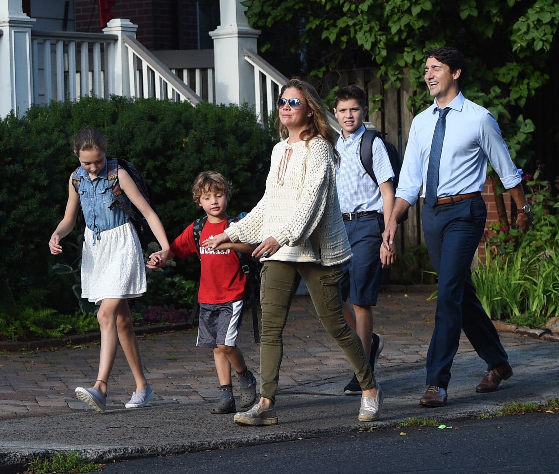 Average dad with car salesman's grin drops kids off at school