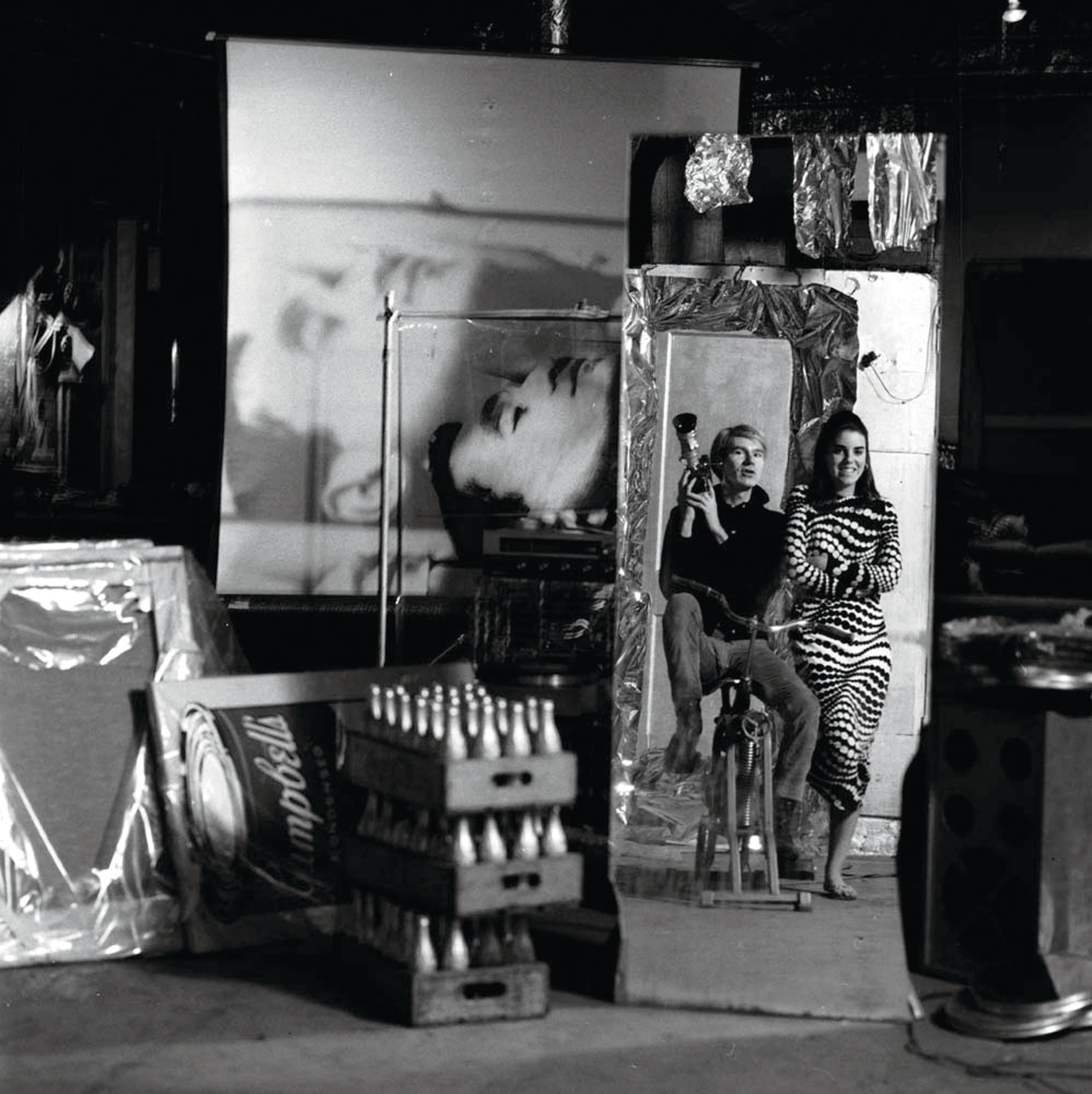 Warhol on a stationary bike next to an unidentified woman in an op-art dress in 1966 (Jerry Schatzberg/Getty Images)