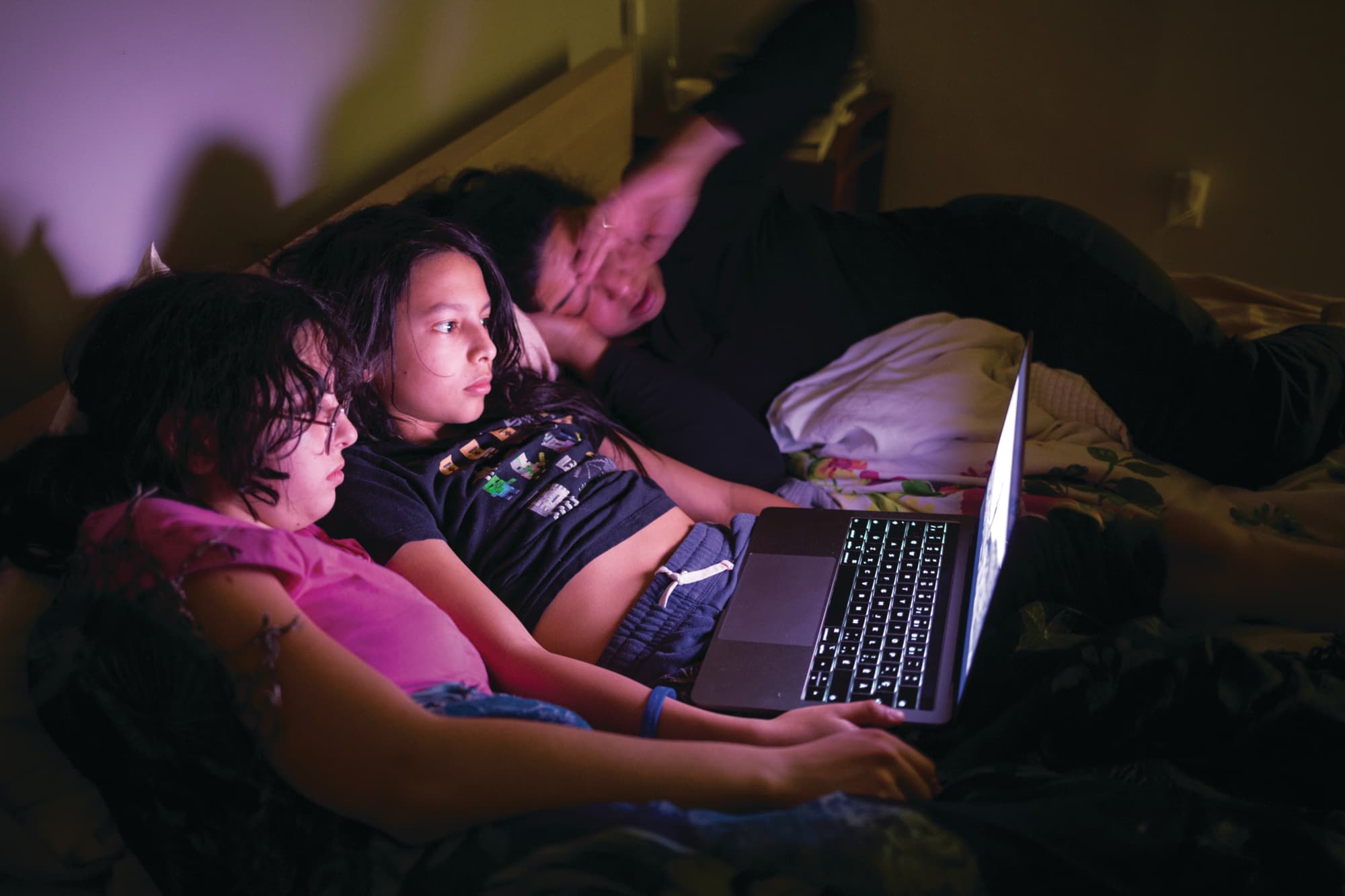 Chloe, Sasha and Lakheeram (left to right) take advantage of a rare opportunity for family movie night (Roger LeMoyne)