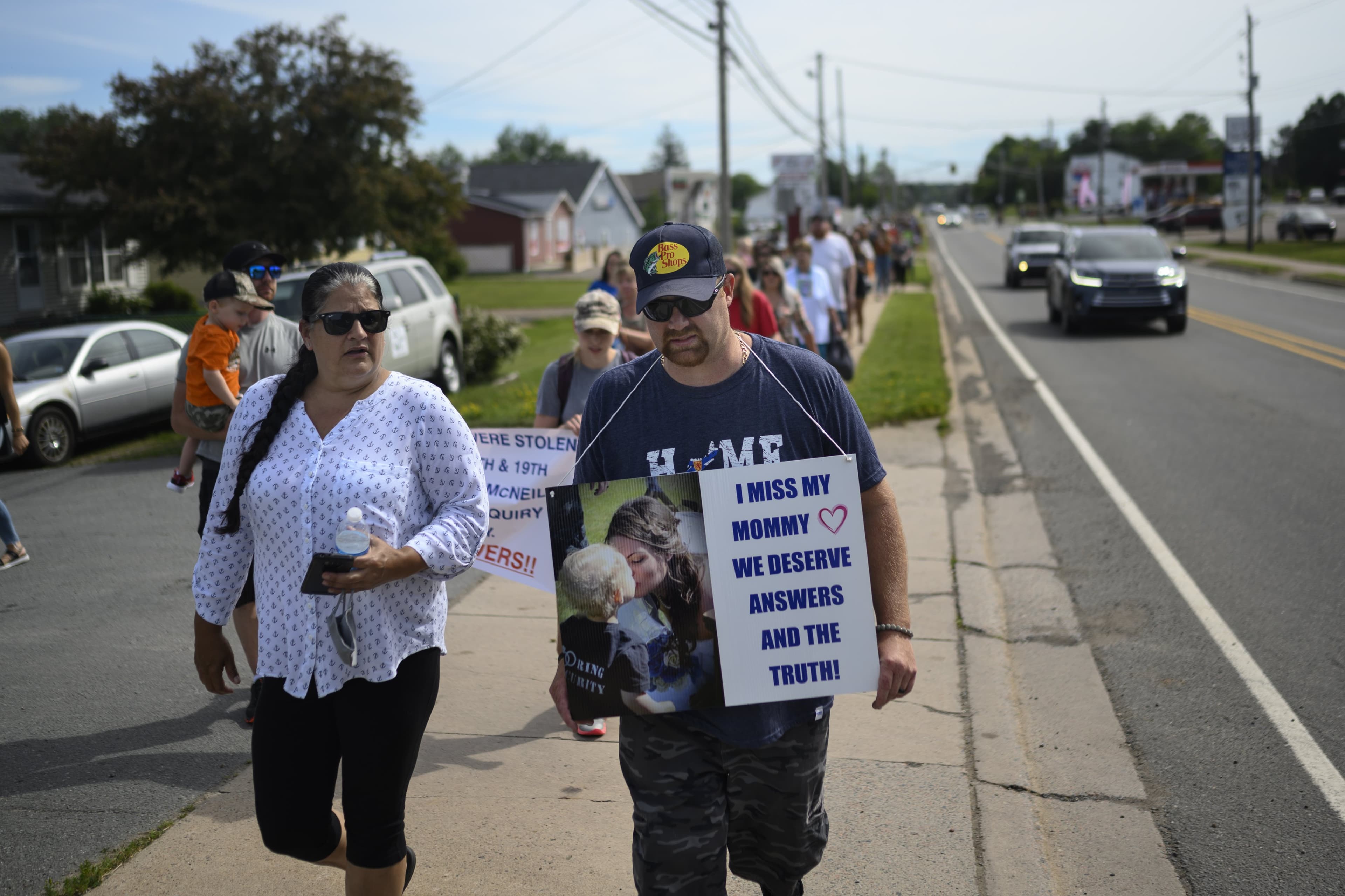 Nick Beaton, centre, wears a sign in memorial of his slain wife Kristen Beaton, as he joins other family members of victims for a march in Bible Hill, N.S. on Wednesday, July 22, 2020 demanding a public inquiry into the RCMP's handling of Canada's deadliest rampage throughout rural Nova Scotia in April. (Photograph by Darren Calabrese)