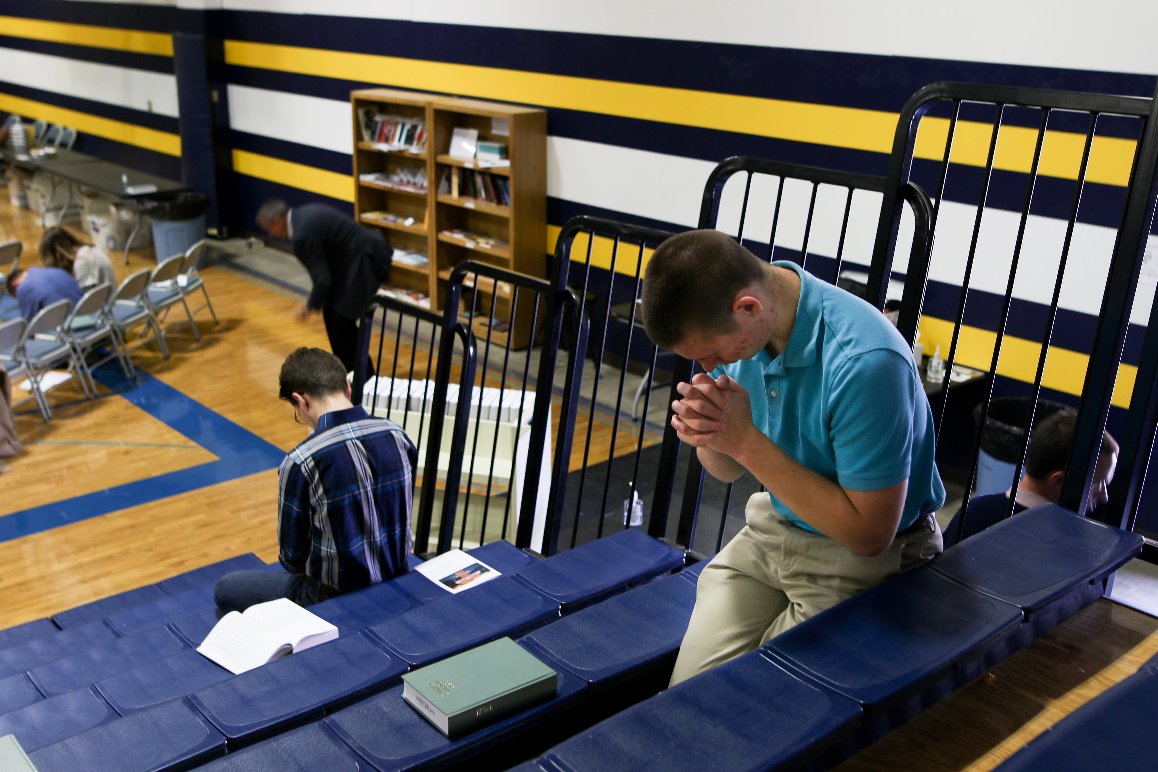 A worshipper prays for forgiveness during Sunday service at the Logos School. Christ Church, a evangelical movement led by PAstor Doug Wilson. (Photograph by Adnan R. Khan)