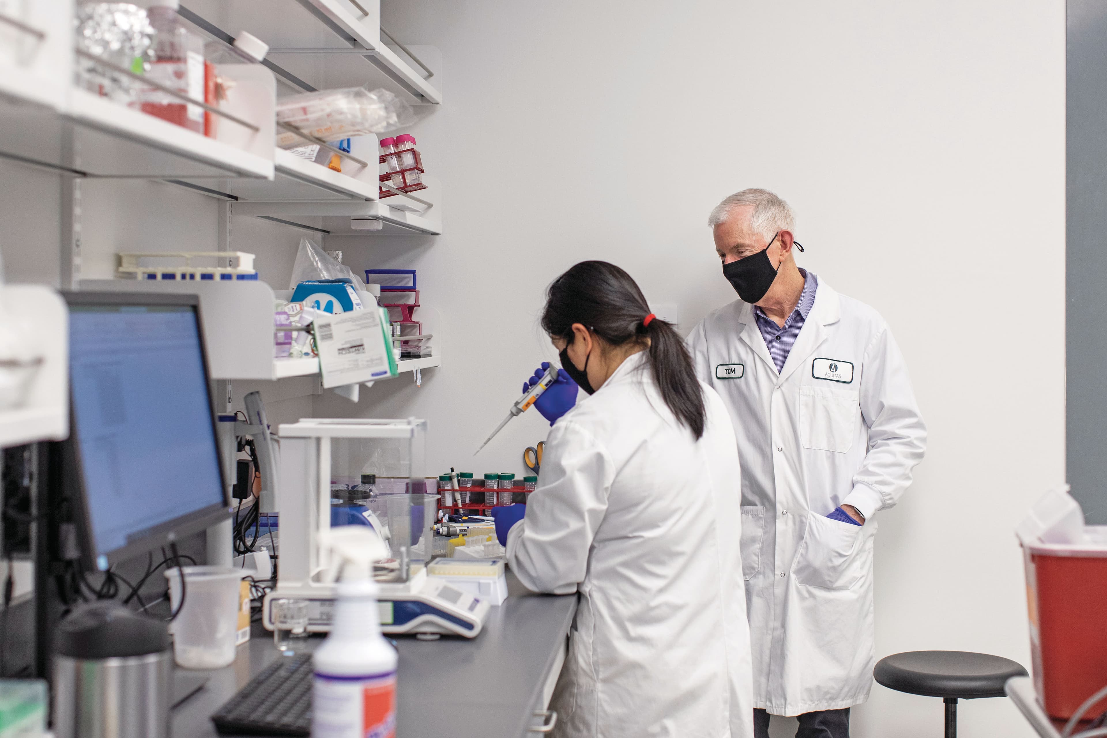 Madden (right) and a colleague at an Acuitas lab in Vancouver (Photograph by Alia Youssef)