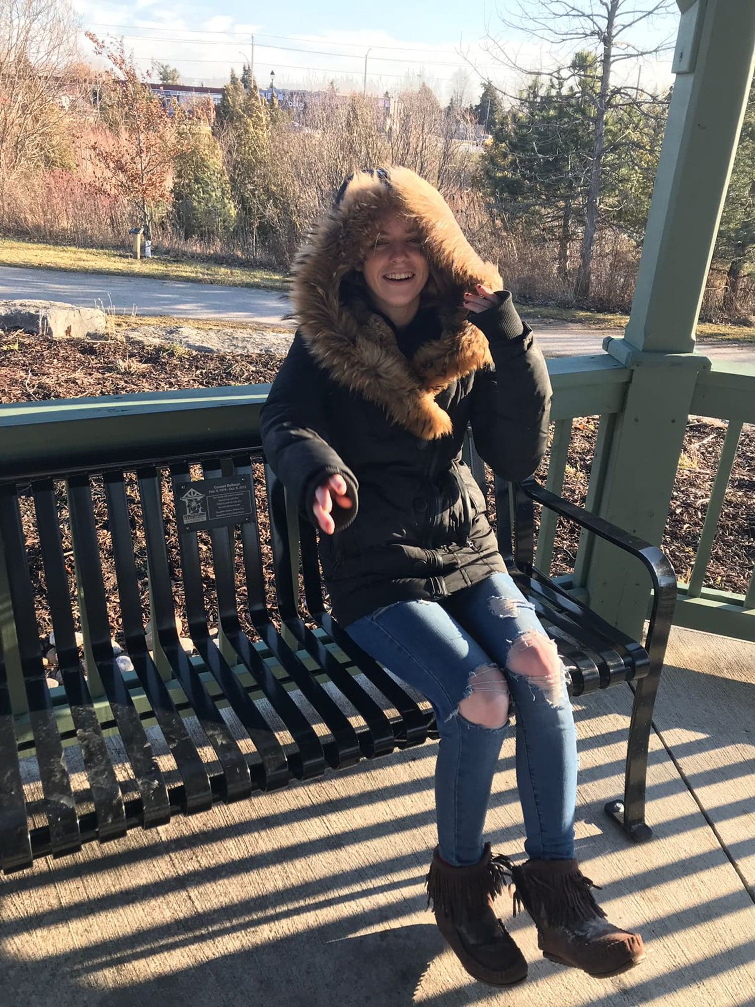 Darian on the memorial bench for her father, Conrad; it now also bears a plaque with her name (Courtesy of Flo Bellman and Paul Henderson)