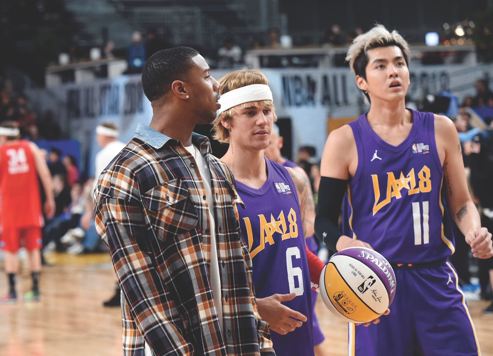 Three men stand on a basketball court