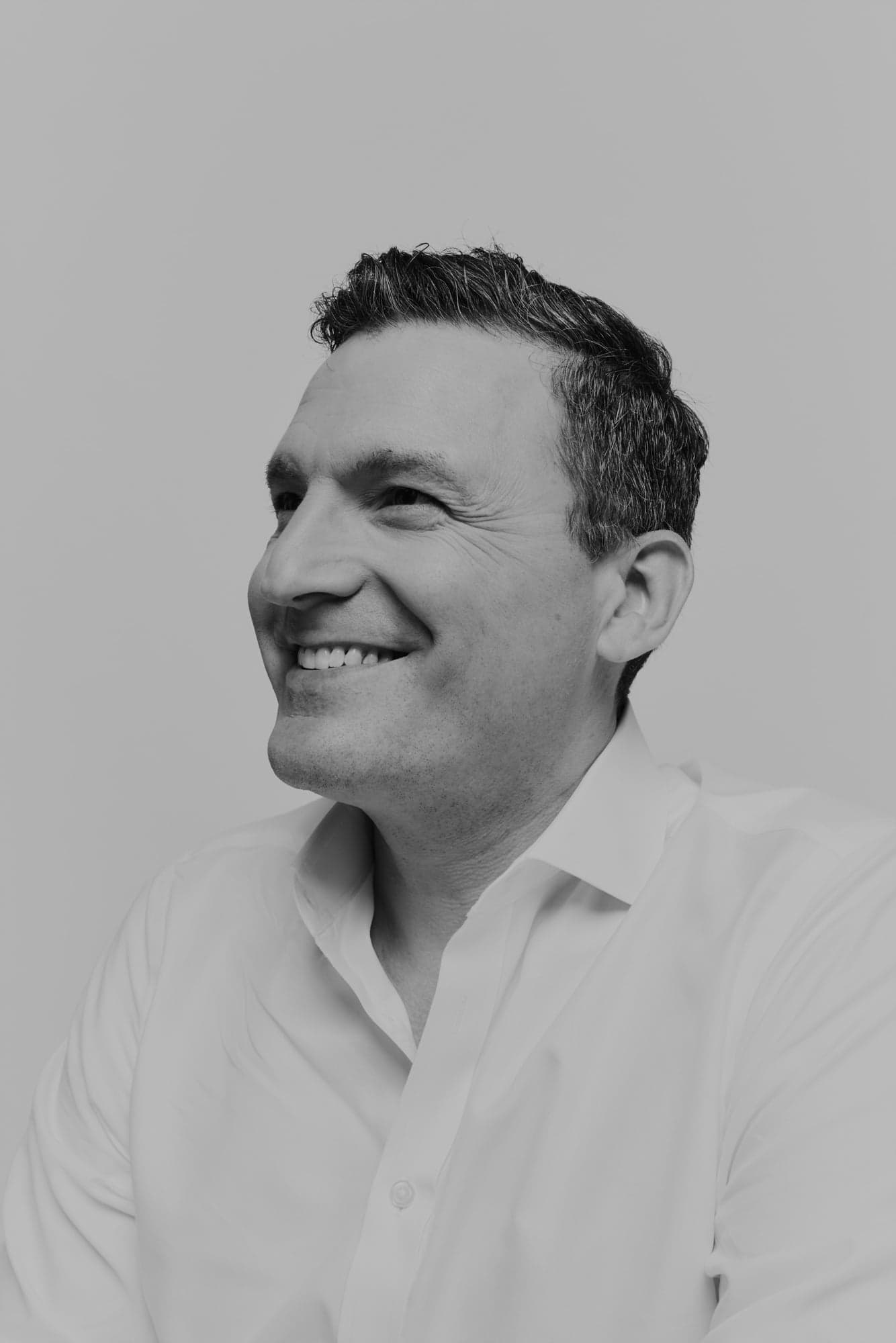 A smiling man in a white shirt