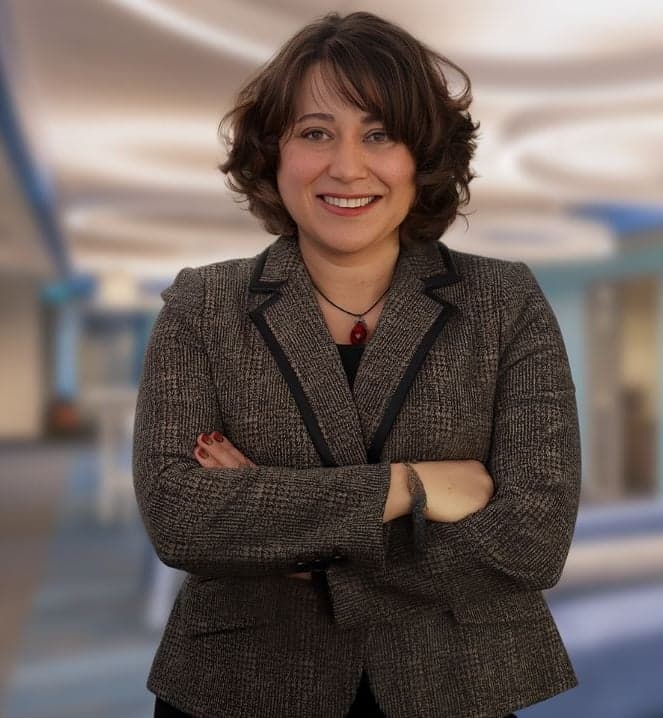 Dr. Secil Ertorer facing the camera, smiling with her arms crossed