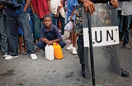 Haitians queue for aid by a UN peacekeep