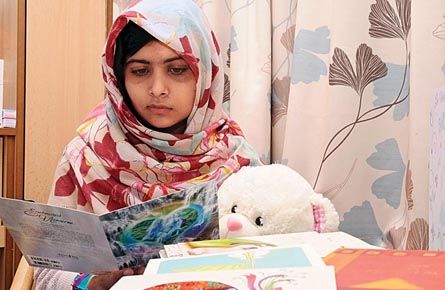 Pakistani schoolgirl Malala reads a card as she recuperates at the The Queen Elizabeth Hospital in Birmingham