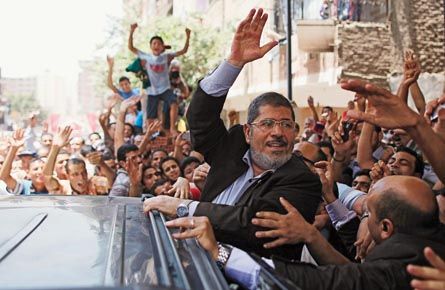 Presidential candidate Mohamed Morsy of the Muslim Brotherhood waves to a crowd outside a mosque after attending Friday Prayers in Cairo