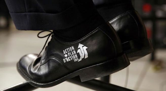 Canada&#8217;s Finance Minister Flaherty wears the Economic Action Plan logo on his shoes during an interview after delivering the budget on Parliament Hill in Ottawa
