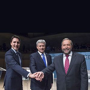Liberal Leader Justin Trudeau, left to right, Conservative Leader Stephen Harper and NDP Leader Thomas Mulcair join hands prior to the Munk Debate on foreign affairs, in Toronto