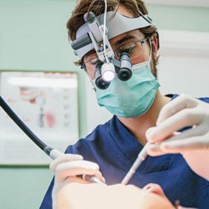 Dentist with microscope glasses during a root canal intervention