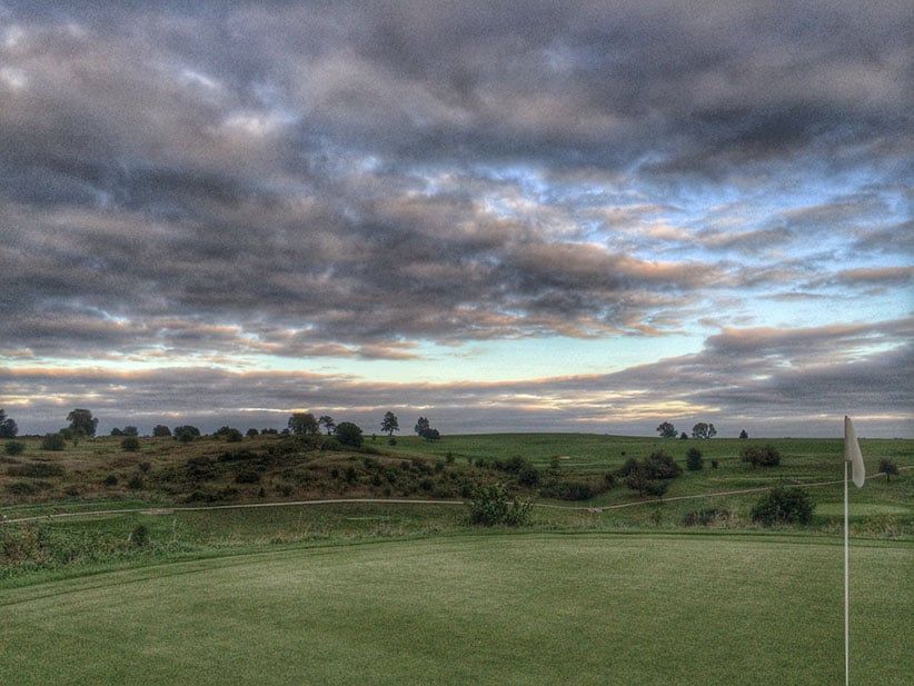Golf Course Against Cloudy Sky At Dusk