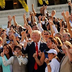 Trump leads his employees in a thumbs-up group photo after a campaign event with them at his Trump National Doral golf club in Miami, Florida