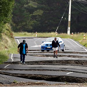 Local residents Chris and Viv Young look at damage caused by an earthquake along State Highway One near the town of Ward, south of Blenheim on New Zealand&#8217;s South Island