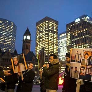 A small group of family and friends of Soleiman Faqiri, hold a vigil at Nathan Phillips Square