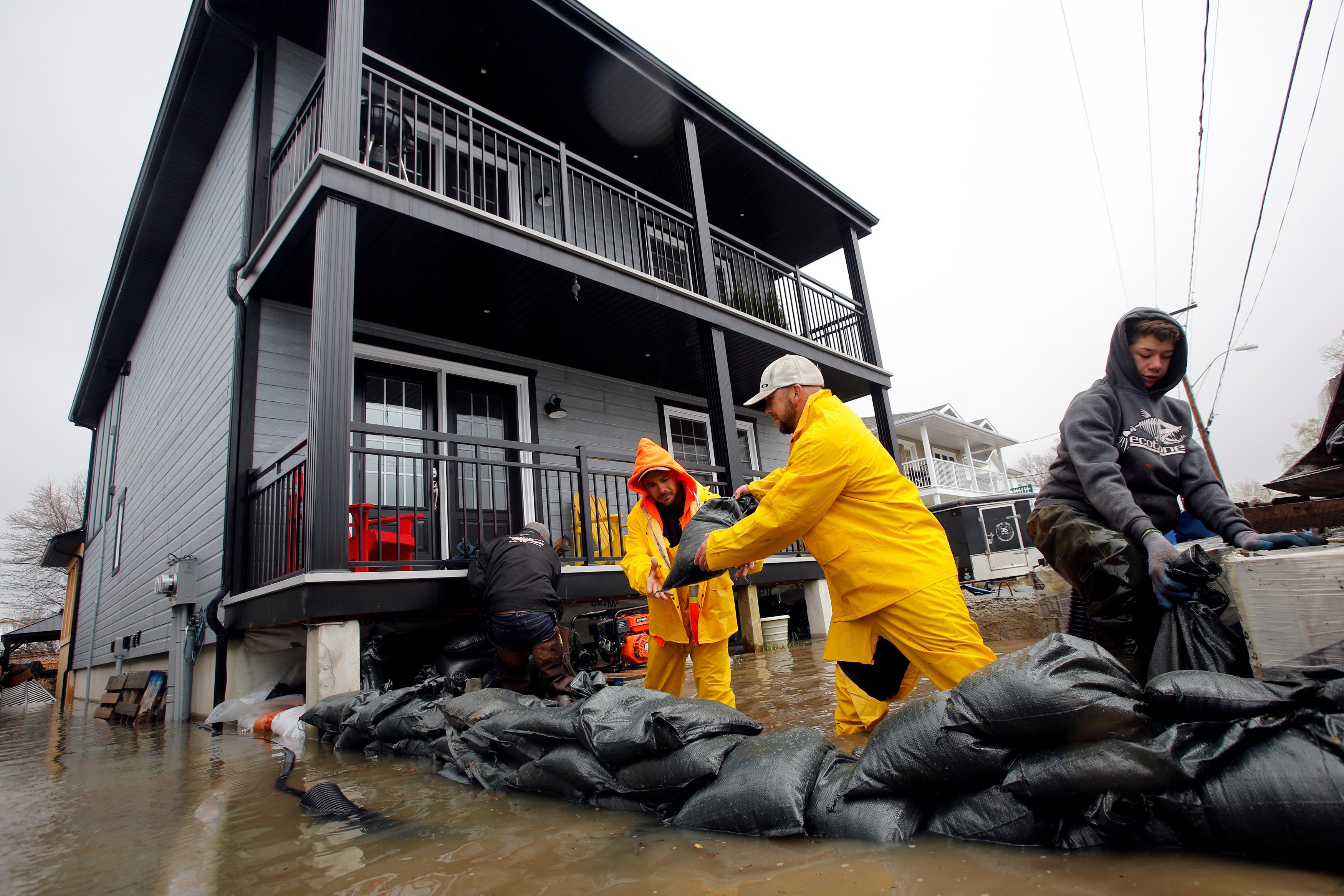 Residents place sandbags outside a home in a flooded residential area in Gatineau