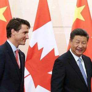Chinese President Xi Jinping gestures to Canadian Prime Minister Trudeau ahead of their meeting at the Diaoyutai State Guesthouse in Beijing