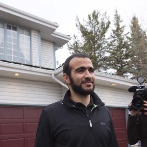 Omar Khadr walks to meet the press before a news conference after being released on bail in Edmonton, Alberta