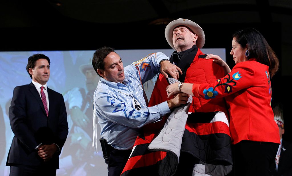 Canada&#8217;s Prime Minister Justin Trudeau looks on as Tragically Hip singer Gord Downie is presented with a blanket during an honouring ceremony at the Assembly of First Nations Special Chiefs Assembly in Gatineau