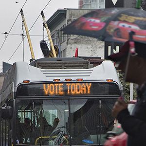 A transit bus reminding people to vote travels in downtown Vancouver