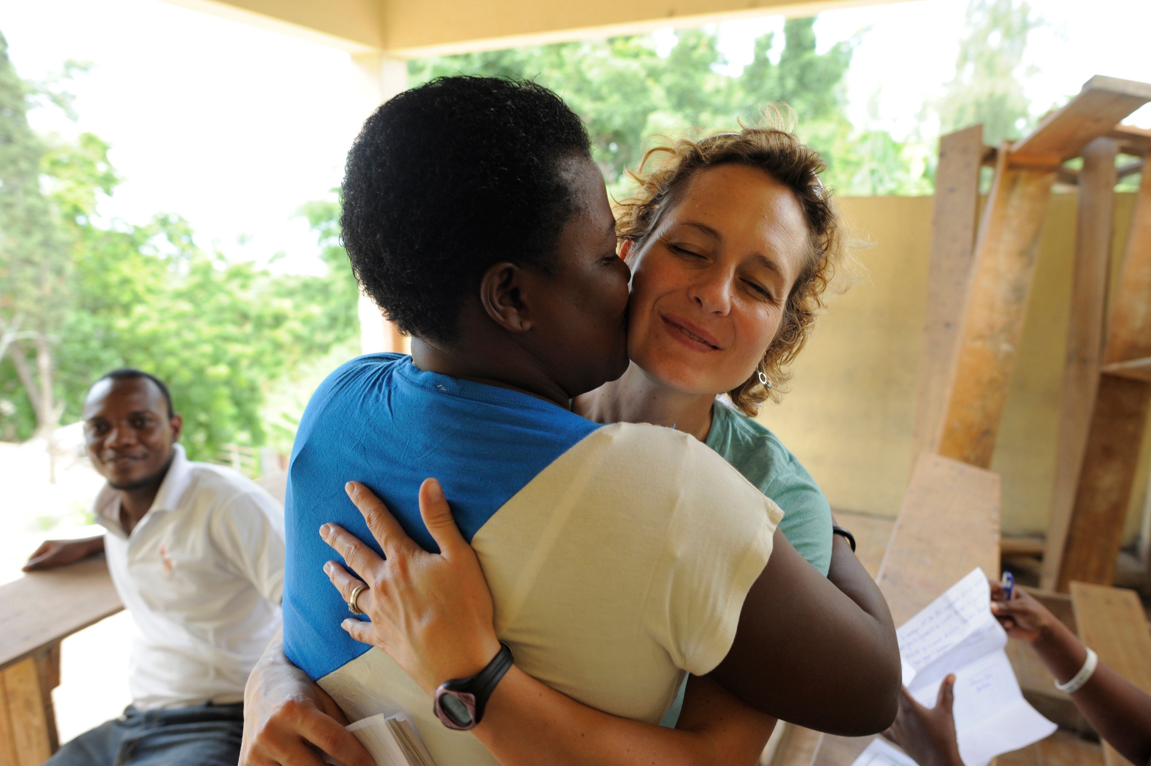 Catherine Porter is embraced by Roselene Derival Fabre(manager of the MOJUBPV) after Porter donated