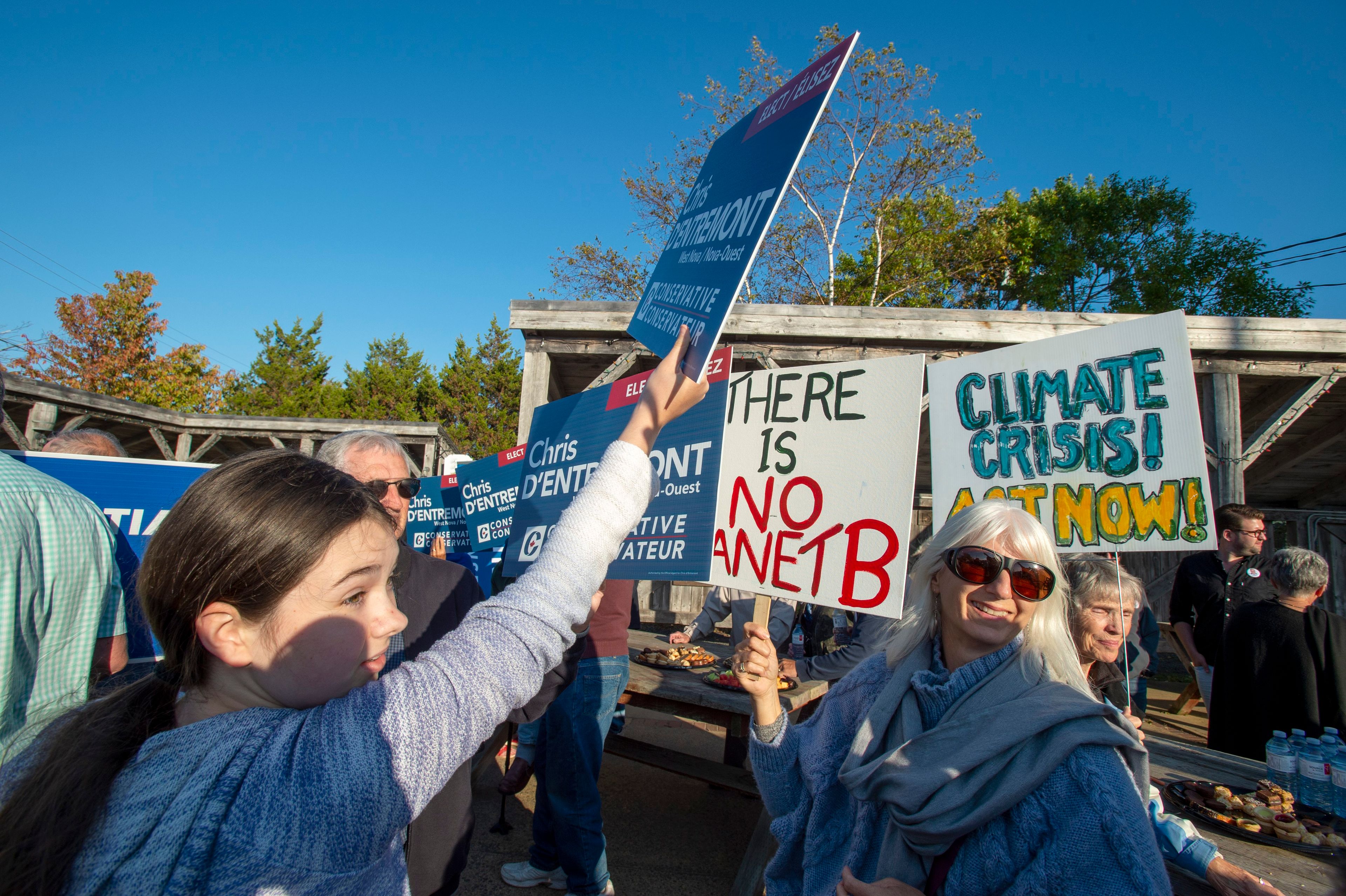 Conservative supporters try to block Climate Change signs before party leader Andrew Scheer's arrival at a rally in Annapolis Royal, N.S., on Sept. 20, 2019. (Frank Gunn/CP)