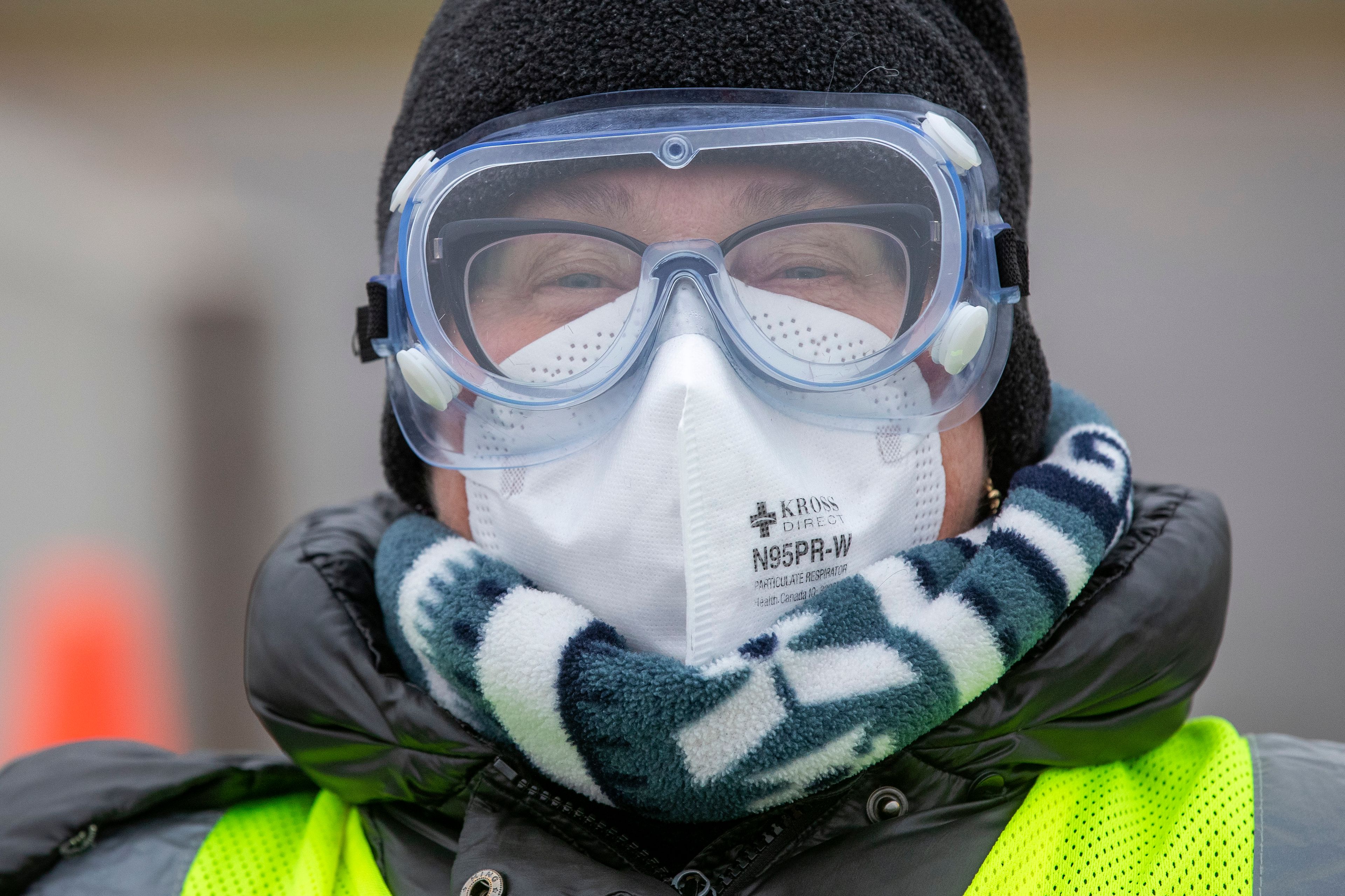 A doctor wears goggles and an N95 mask during a drive through COVID-19 vaccine clinic in Kingston, Ont., Dec. 18, 2021. (Lars Hagberg/The Canadian Press)