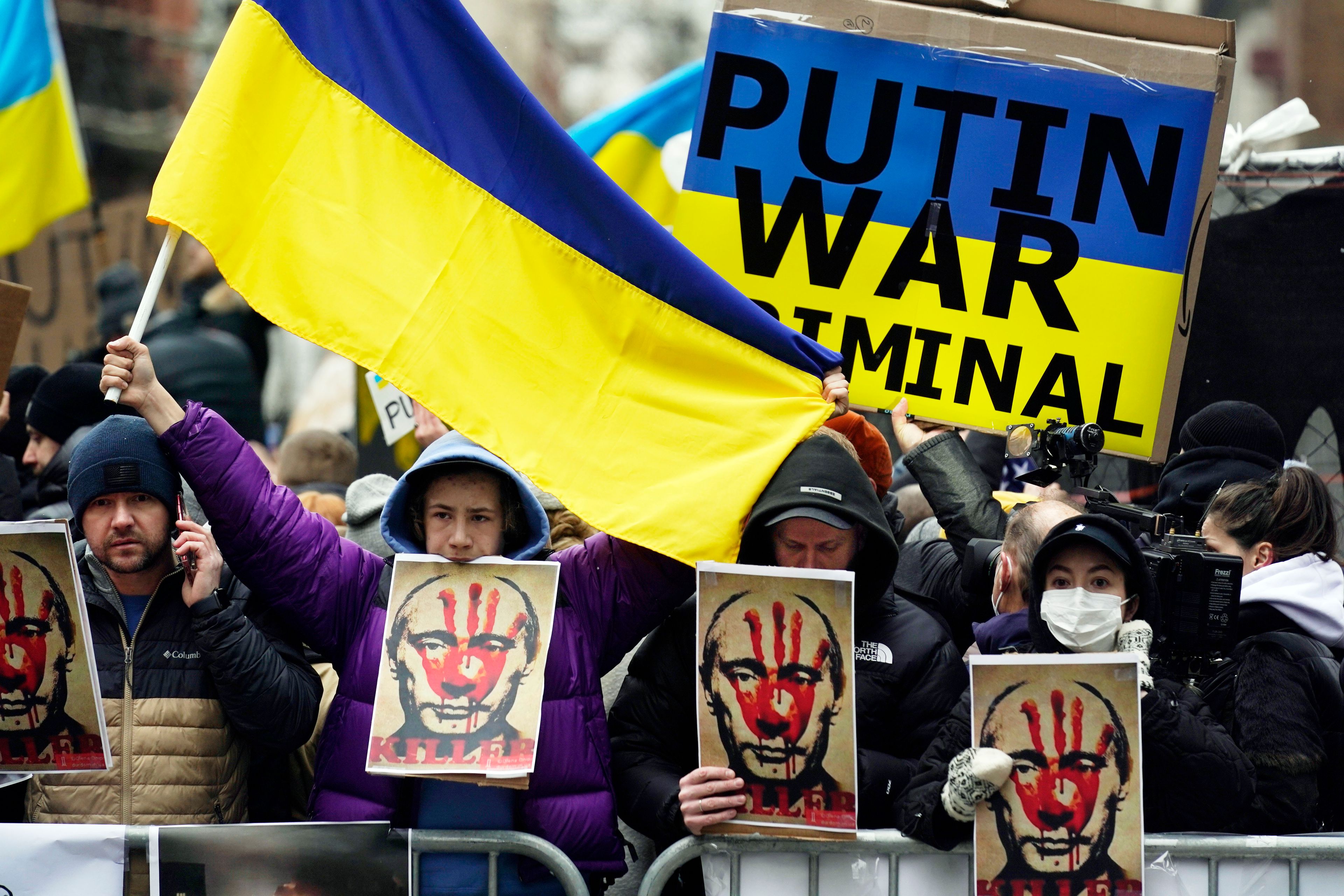 Pro-Ukraine demonstrators carry signs and Ukraine flags near Russia's UN Mission on Feb. 24, 2022 (AP Photo/Seth Wenig)