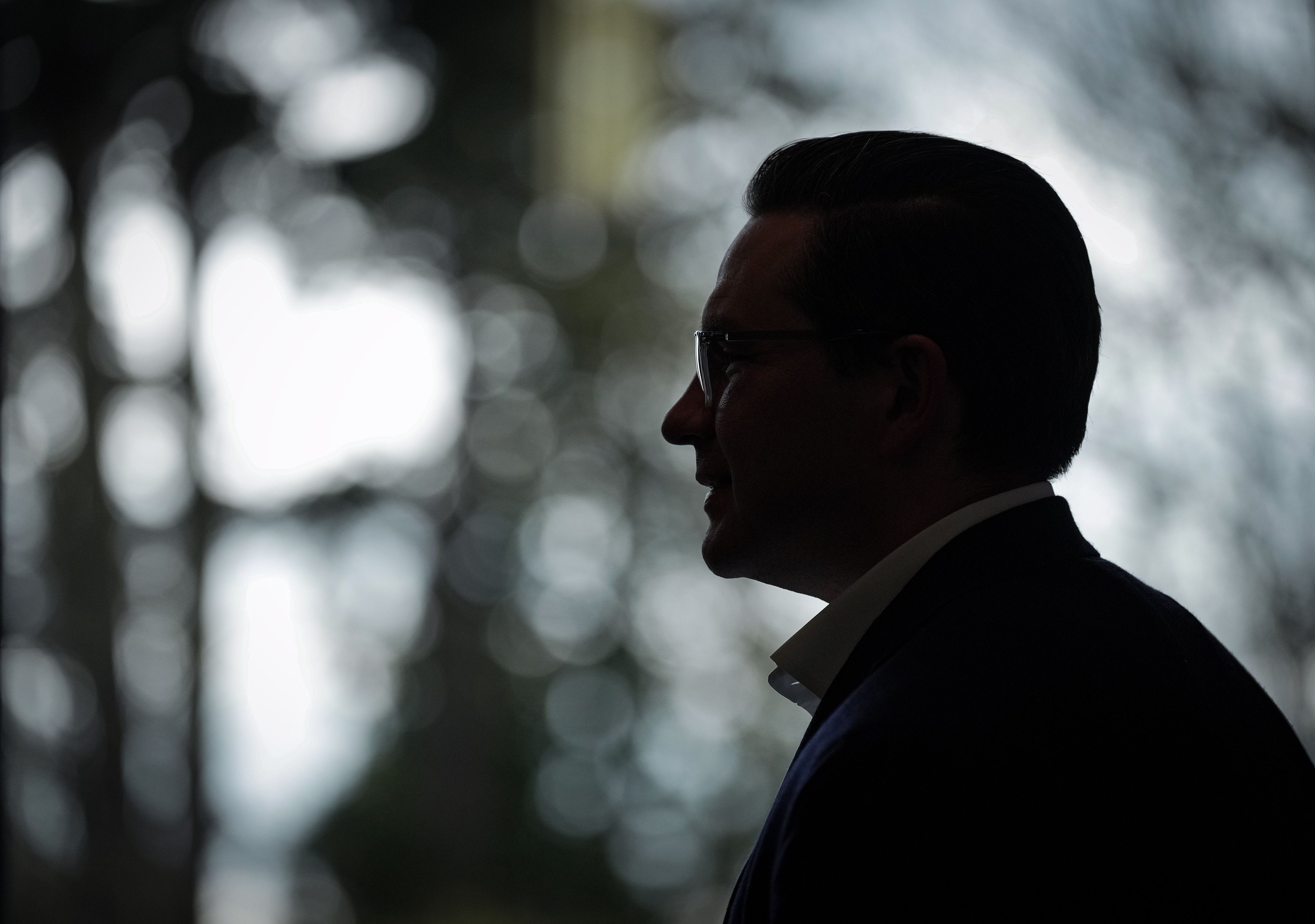 Poilievre is silhouetted during a meet and greet at the University of British Columbia, in Vancouver, April 7, 2022. (Darryl Dyck/The Canadian Press)