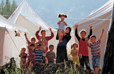 Syrian refugee children pose at a refugee camp in the Turkish border town of Yayladagi in Hatay