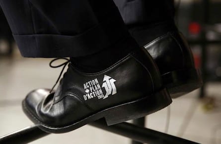 Canada's Finance Minister Flaherty wears the Economic Action Plan logo on his shoes during an interview after delivering the budget on Parliament Hill in Ottawa