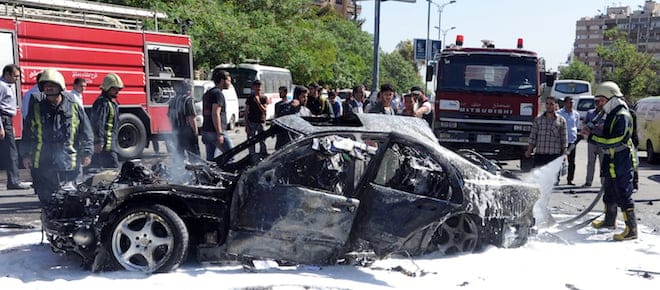 This photo released by the Syrian official news agency SANA, shows Syrian fire fighters extinguishing burning cars after a car bomb exploded in the capital's western neighborhood of Mazzeh, in Damascus, Syria, Monday, April. 29, 2013. State-run Syrian TV says the country's prime minister has escaped an assassination attempt when a bomb went off near his convoy. The TV says Prime Minister Wael al-Halqi was unhurt in the attack in the capital's western neighborhood of Mazzeh. (AP Photo/SANA)