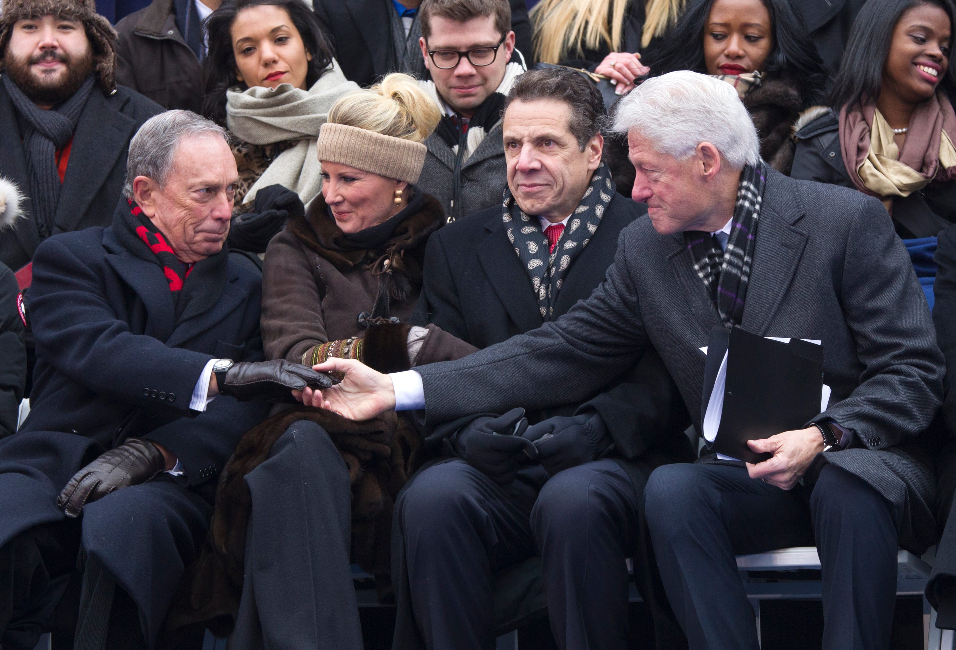 Former U.S. President Bill Clinton offers his hand to former New York City Mayor Michael Bloomberg after acknowledging him in his speech during the inauguration ceremony for New York City Mayor Bill de Blasio in New York