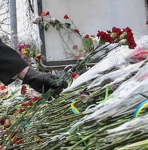 Canada's Foreign Minister John Baird lays flowers at a make-shift memorial for those killed in recent violence in Kiev