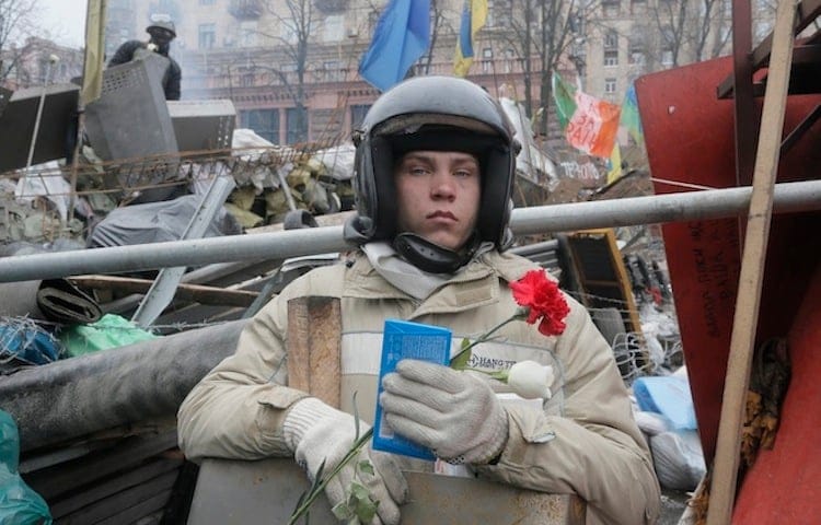 Armed with a chocolate bar and red carnation, a protester guards the barricades to Independence Square. (Efrem Lukatsky, AP Photo)