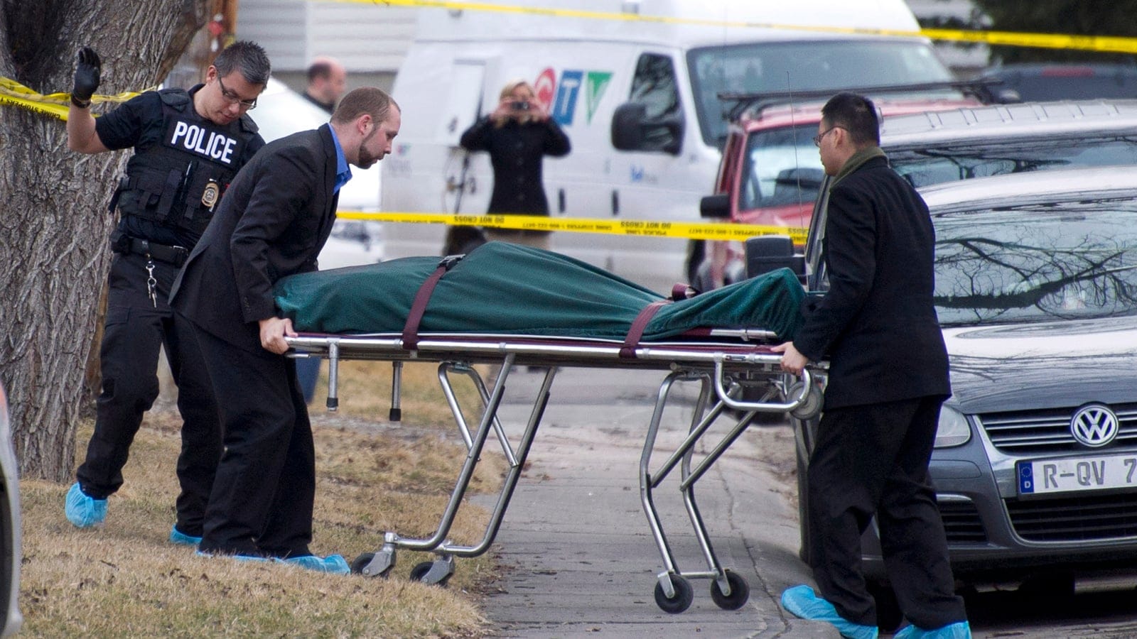 Police remove a body from the scene of a multiple fatal stabbing in northwest Calgary, Alberta on Tuesday, April 15, 2014. Police say five people are dead after a stabbing at a house party. THE CANADIAN PRESS/Larry MacDougal